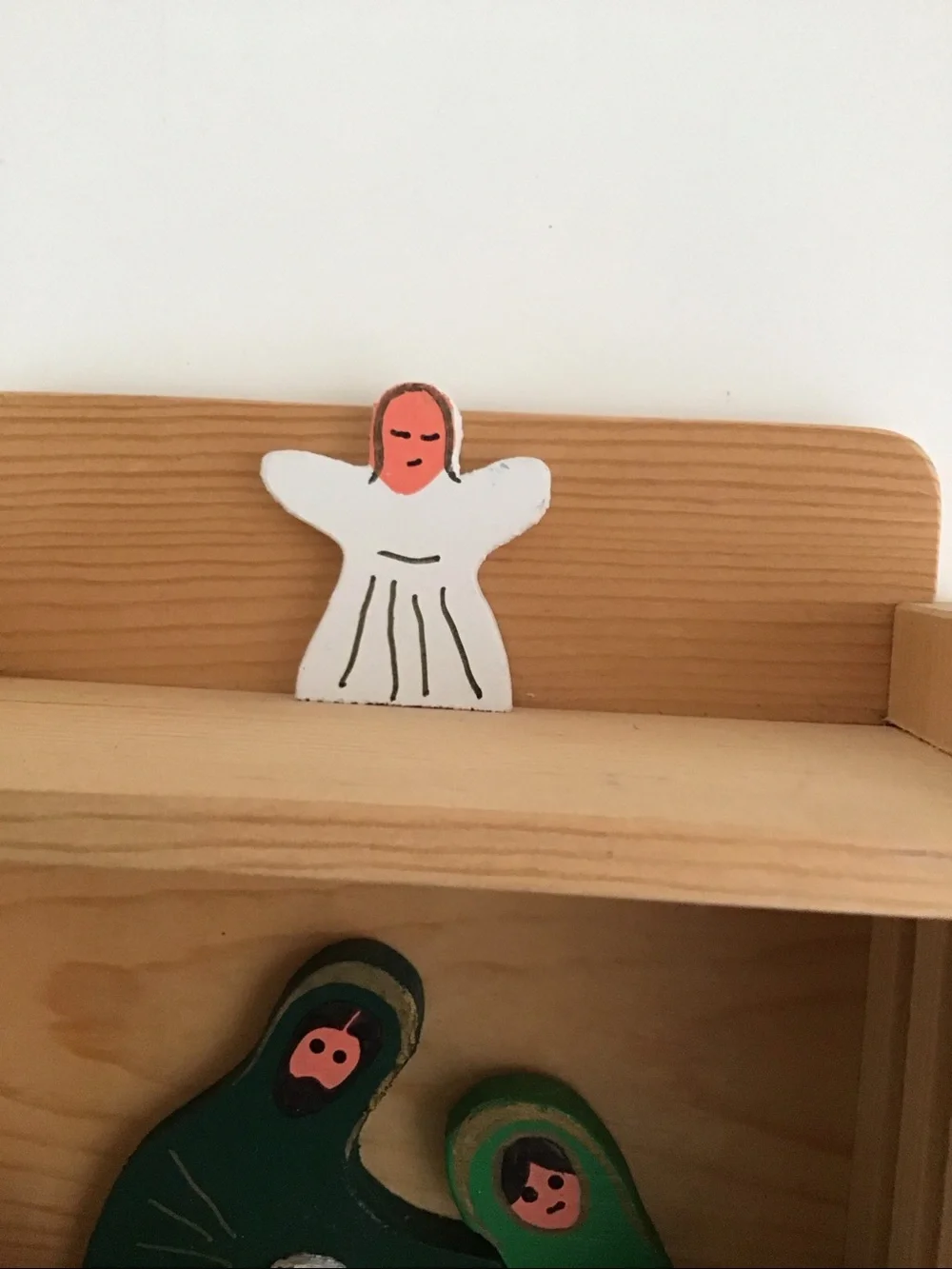 Handmade wooden cabinet holding a small wooden Nativity set